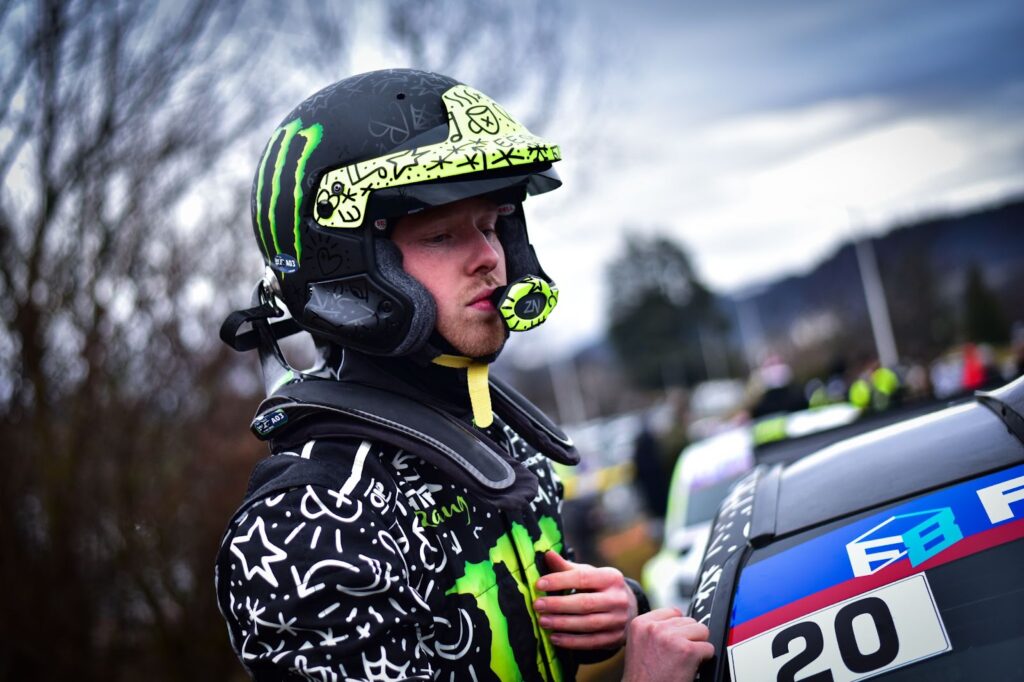 Rally driver wearing helmet and FHR device.